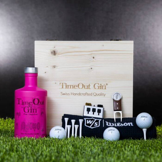 TimeOut Gin Geschenkbox mit Golf-Accessoires auf grünem Rasen, ideal für Golfliebhaber und Genussfreunde.